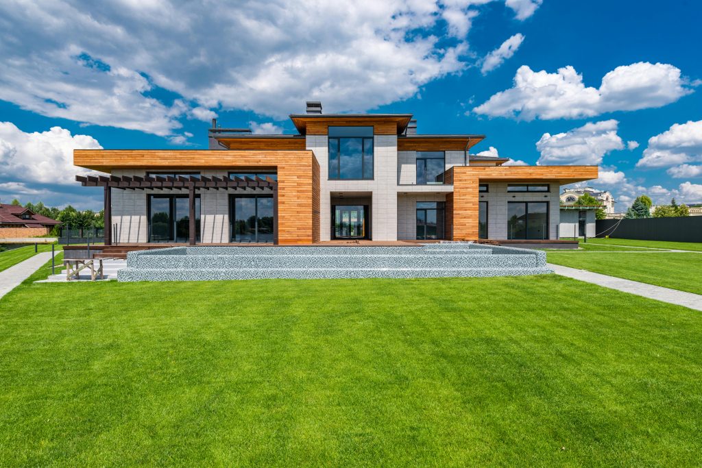 Services Exterior of contemporary building with green grass in yard in daytime under blue sky