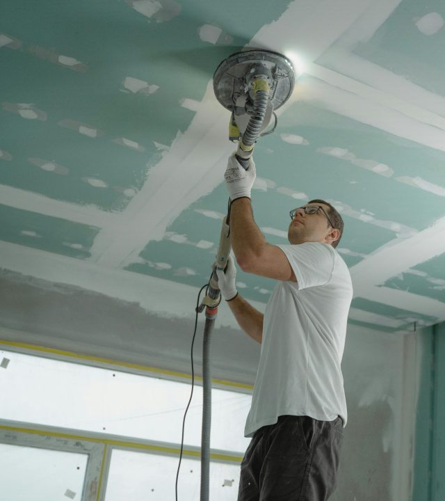 pexels photo 6474343 6474343 A professional worker sanding the ceiling during a home renovation project. Indoor construction setting.